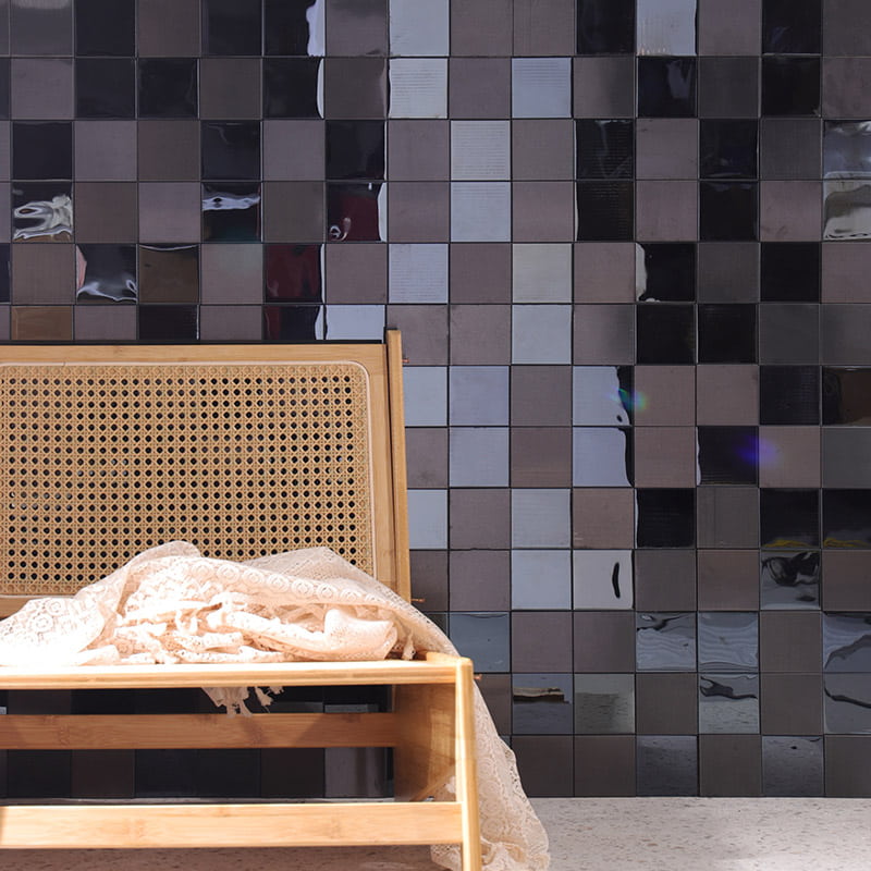 Metal wall tiles with glossy and matte square finish behind wooden chair