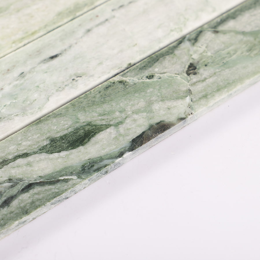 Angled view of Ming green vertical natural marble mosaic tile surface.
