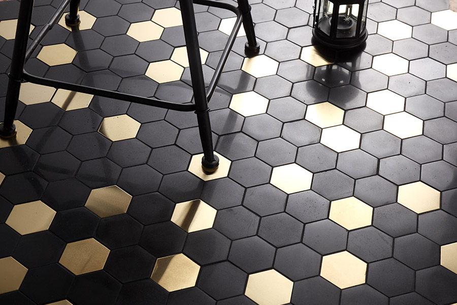 Modern honeycomb pattern featuring black and gold hexagon floor tiles in a chic setting.