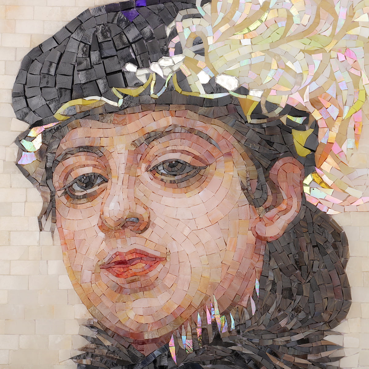 Close-up mosaic of woman’s face with hat and iridescent feather