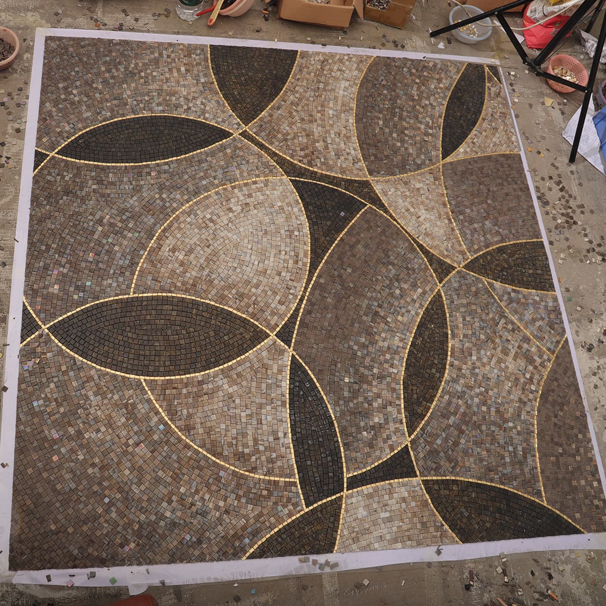 Geometric mosaic floor tile with brown and gold circular patterns