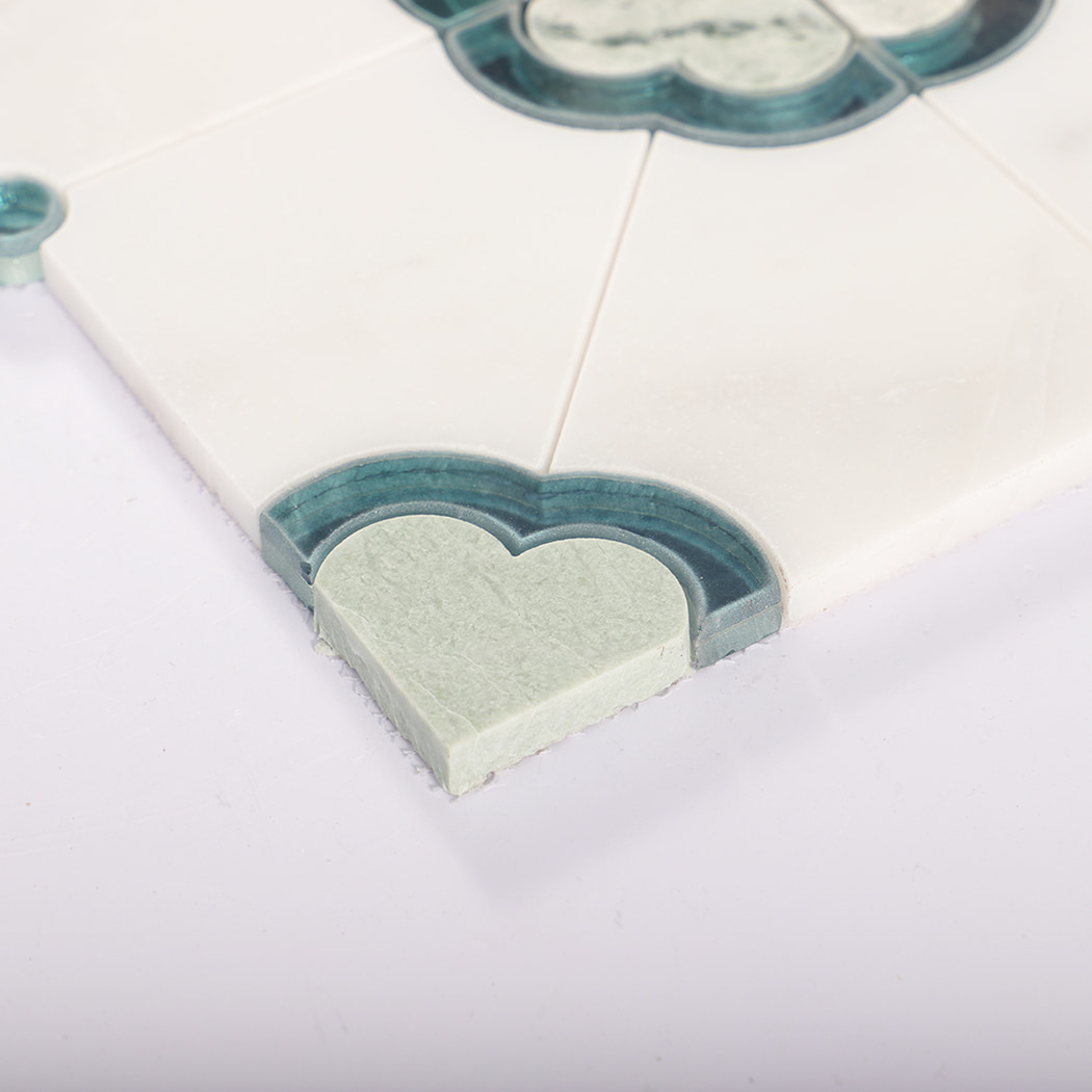 Close up of tile edge with corner motif and layered blue glass trim