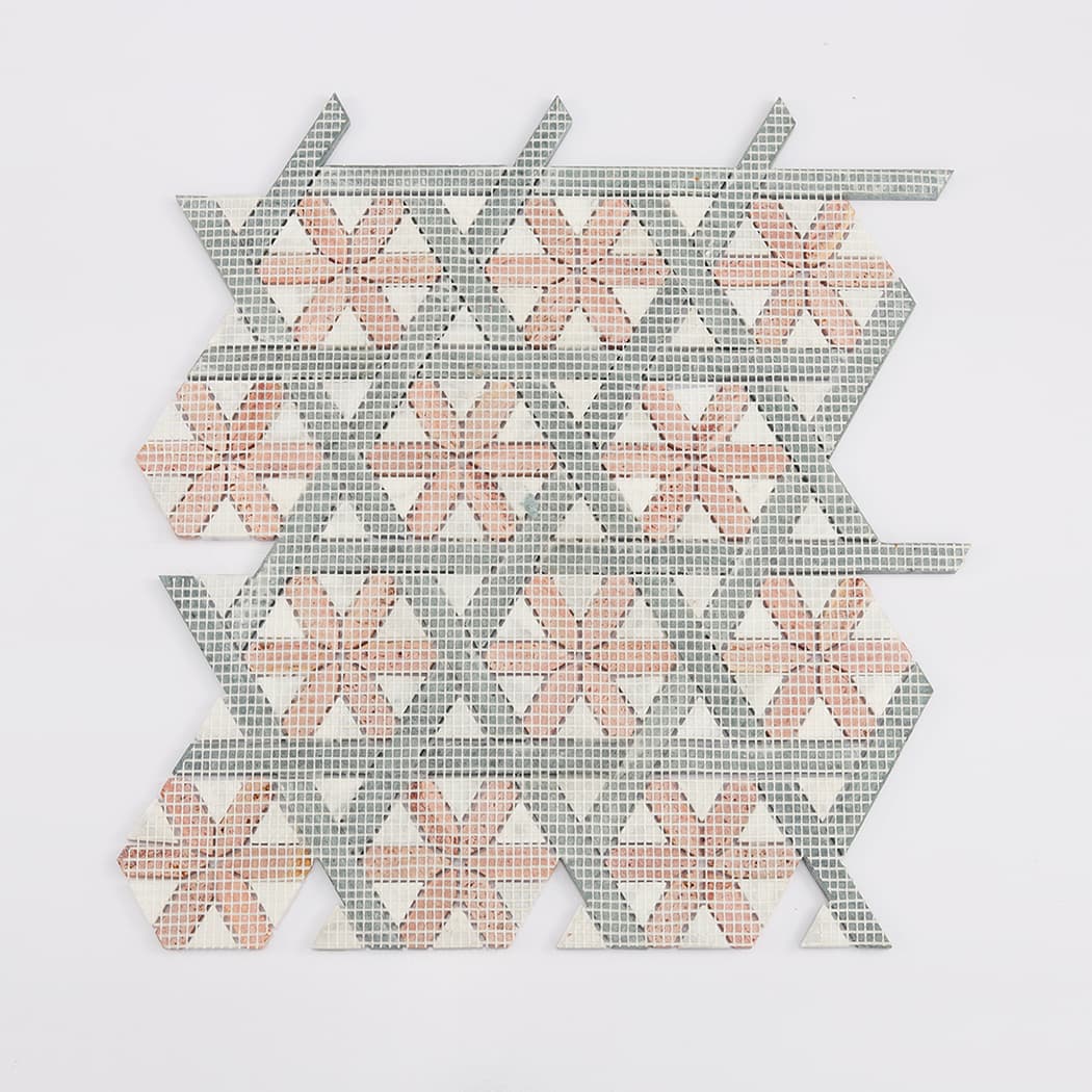 The reverse side of a marble mosaic tile sheet, revealing the fiberglass mesh support.