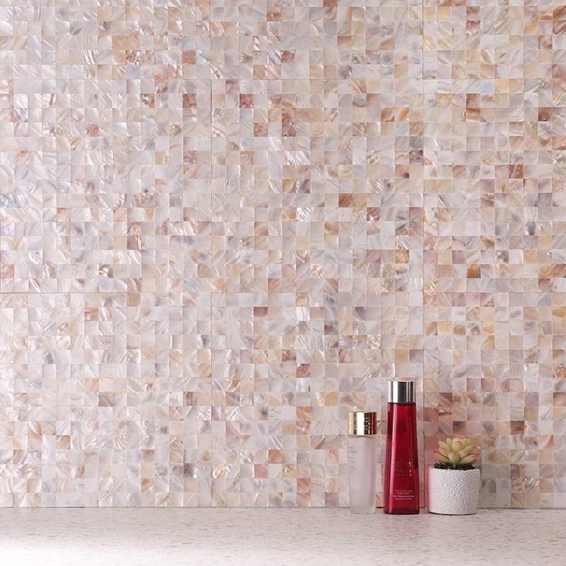 Mother of Pearl square tiles wall with cosmetics and plant