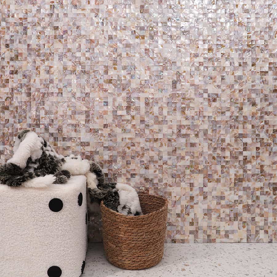 Multicolor shell mosaic tile wall with dice-shaped stool and basket