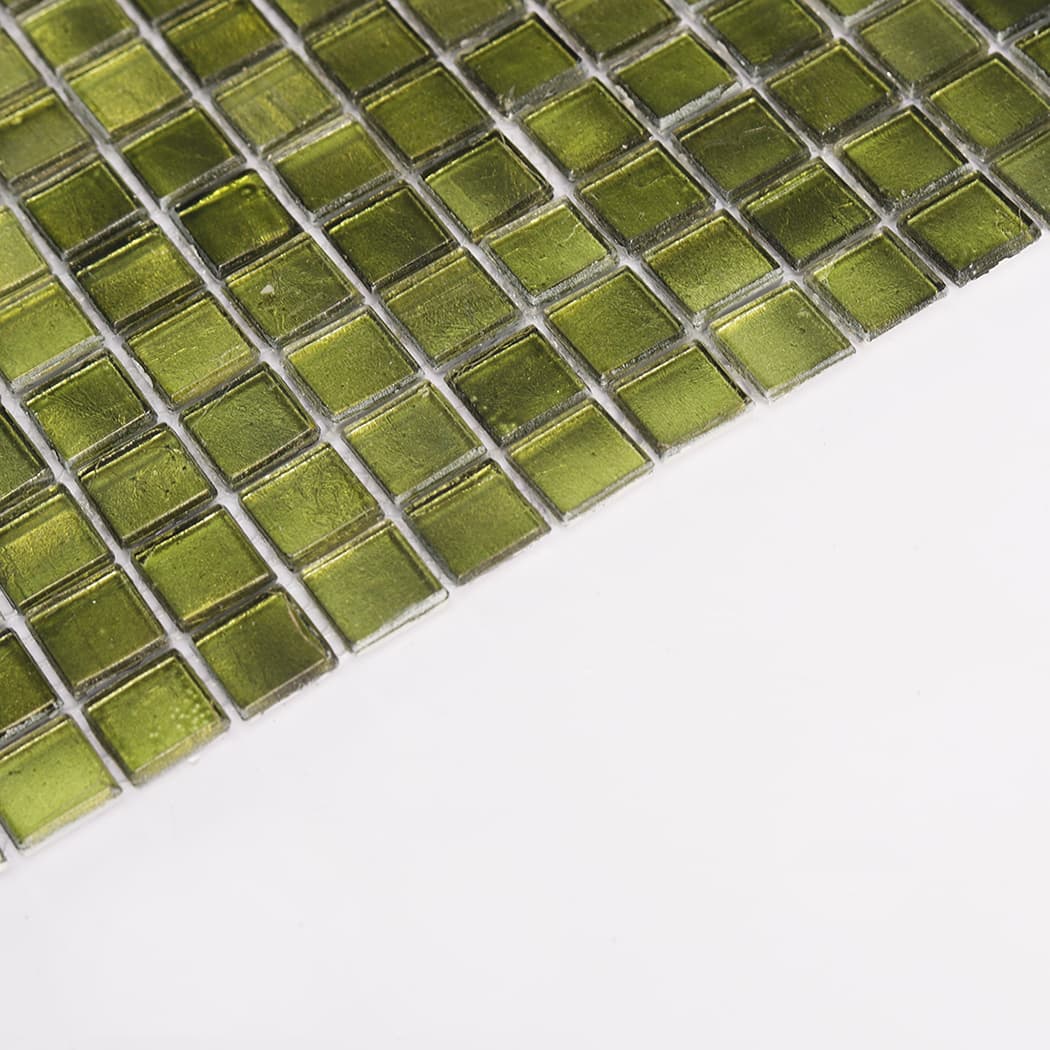 angled edge view of olive green glass mosaic tile sheet on white background