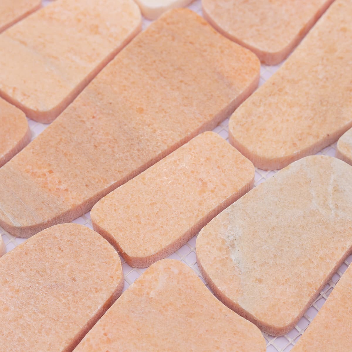 Close-up of textured surface on orange marble mosaic pieces