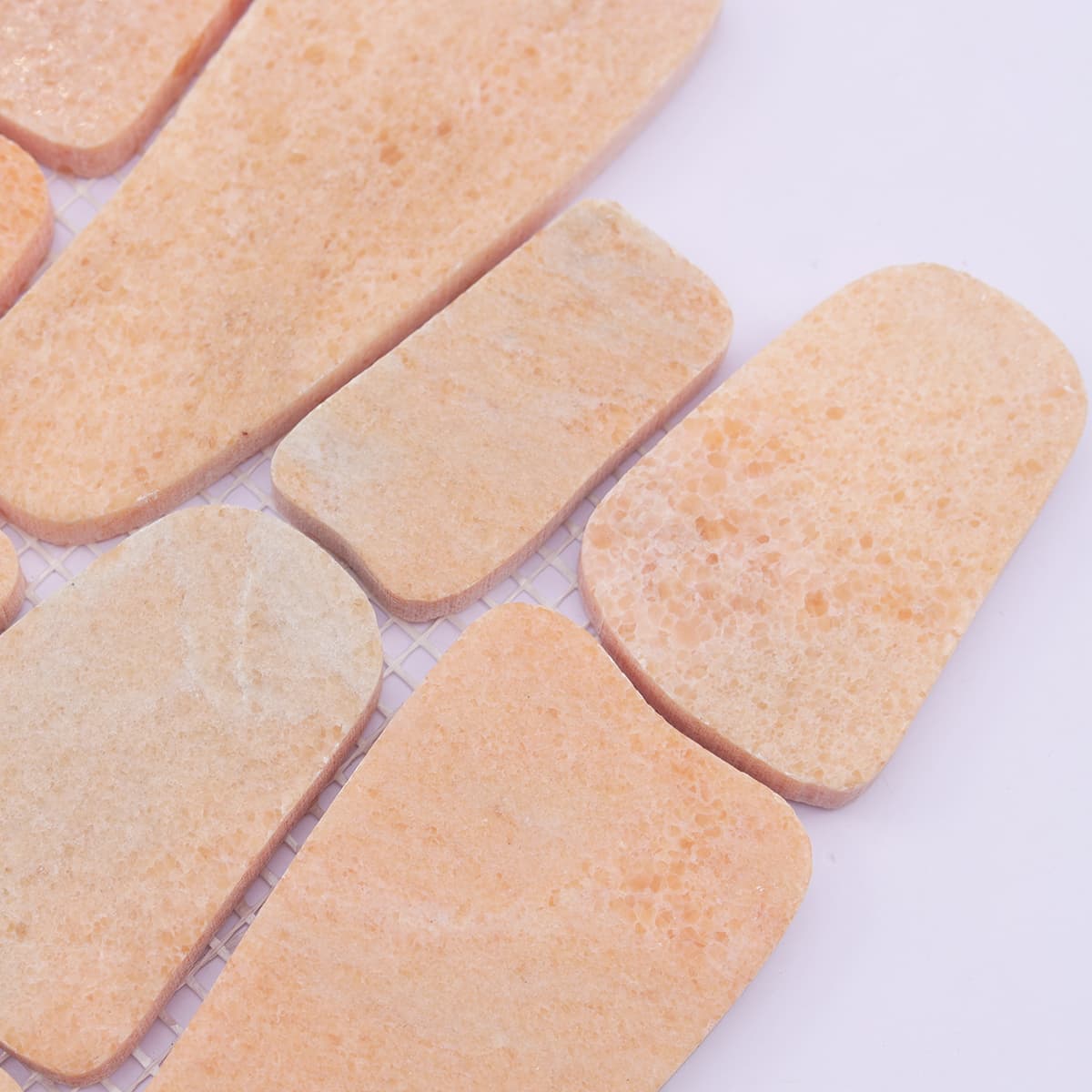 Detail of irregular edge and texture on orange marble mosaic