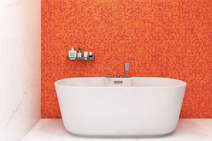 Bright orange glass mosaic tile wall as bathroom backdrop with freestanding tub
