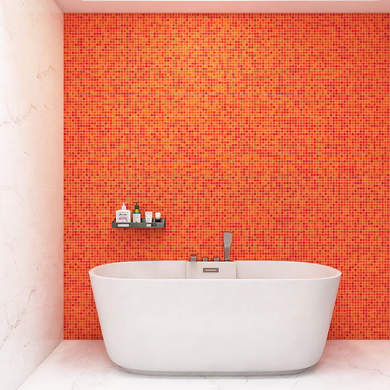 Orange bathroom tiles in red and orange glass mosaic behind modern white bathtub