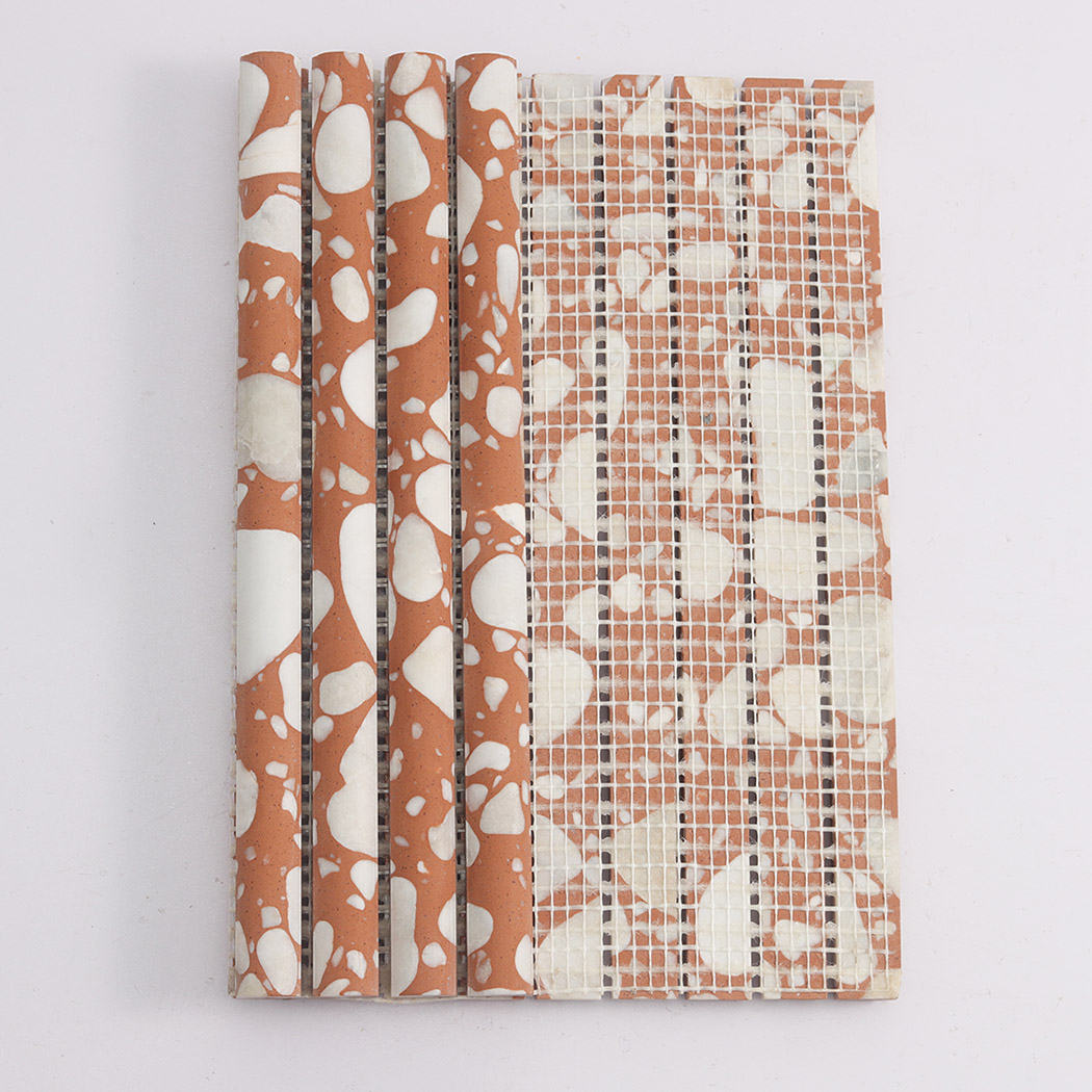 Back view of orange terrazzo fluted mosaic tile showing fiber mesh backing