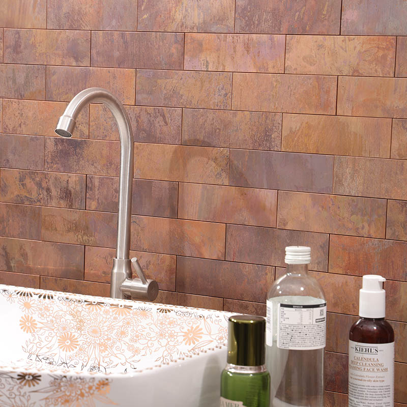 Oxidized copper subway tile bathroom wall with warm aged metal tones