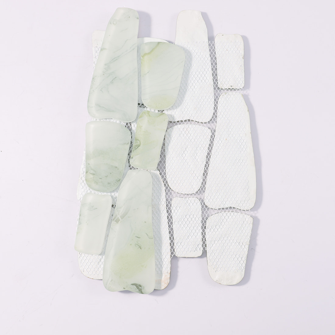 Mesh backing of pale green irregular glass mosaic tile sheet