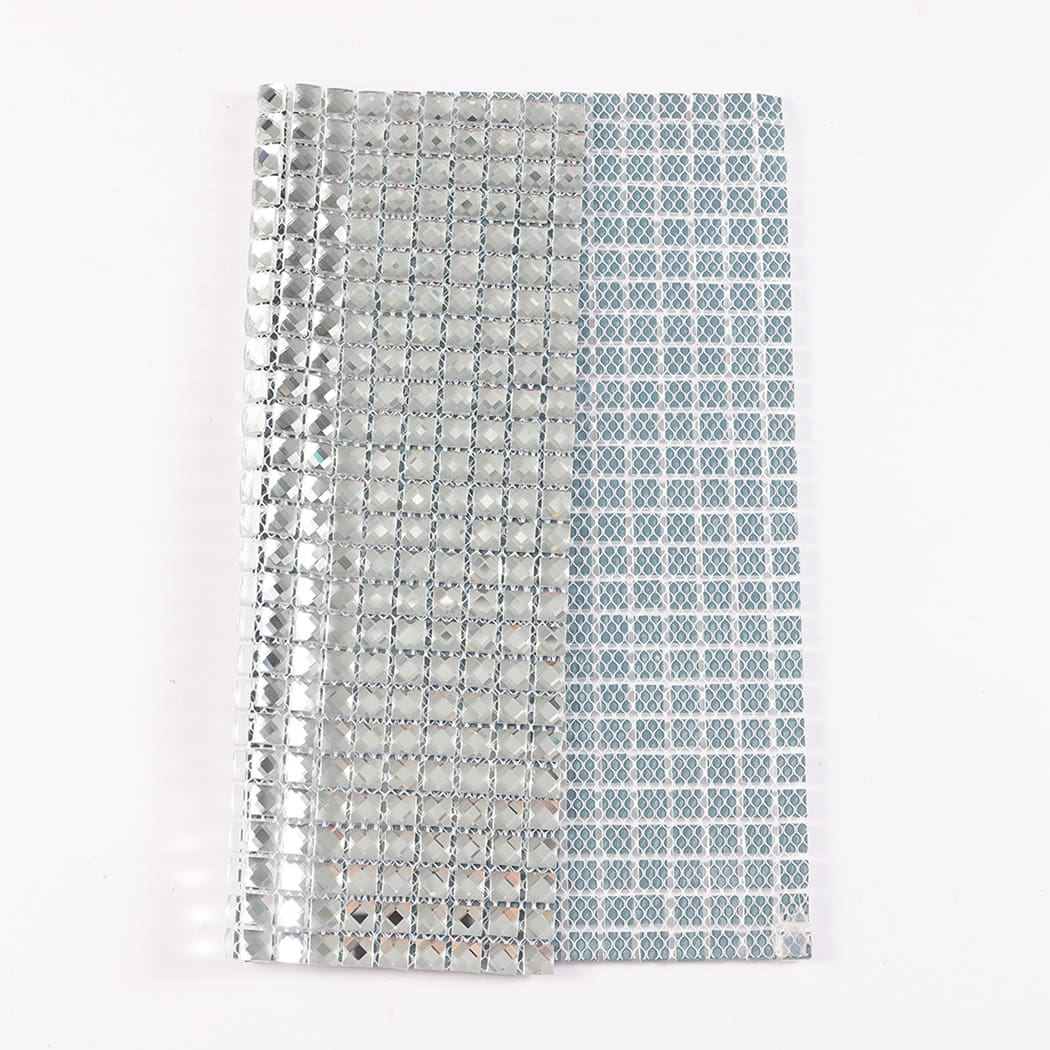 Partial sheet of clear glass mosaic tiles with the reverse side backing mesh visible.