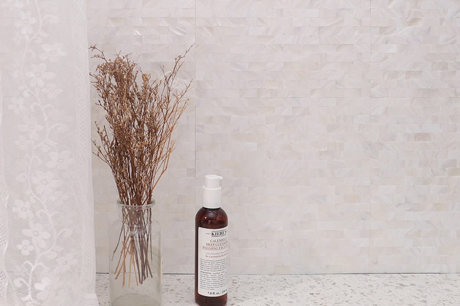 Pearl subway tiles in cream white mother of pearl finish with glass vase and Kiehls bottle decor