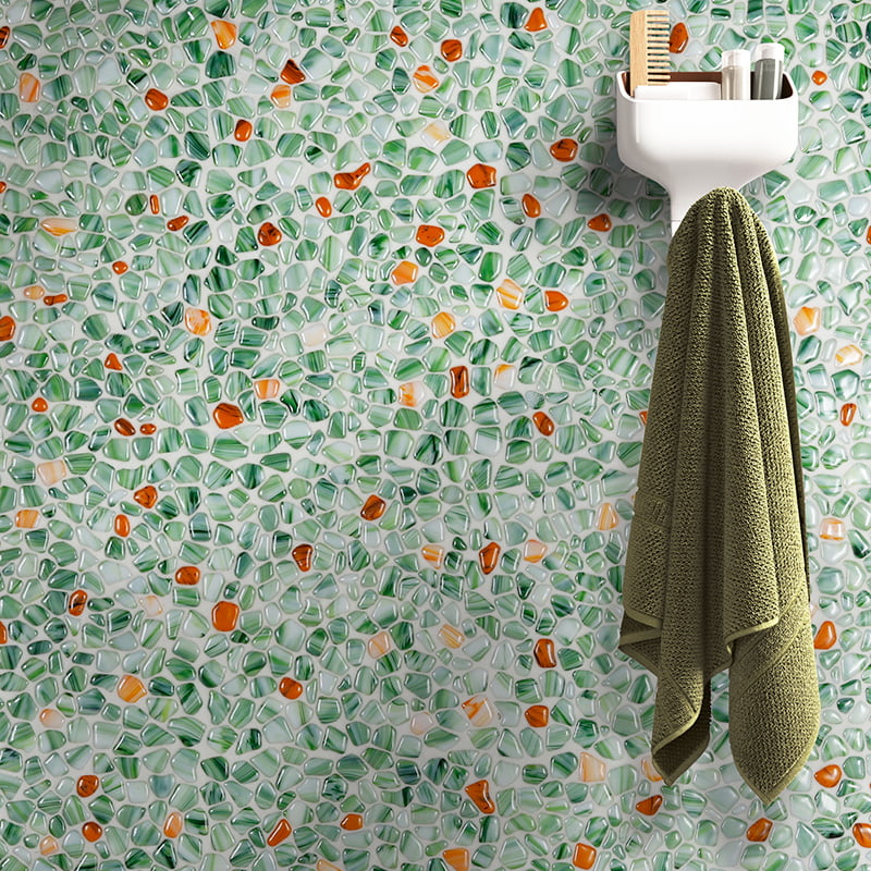 Close-up of green and orange pebble wall tiles with towel hanger