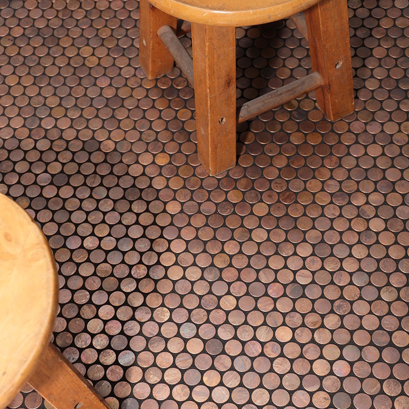 Copper penny round mosaic tiles on the floor with wooden stools