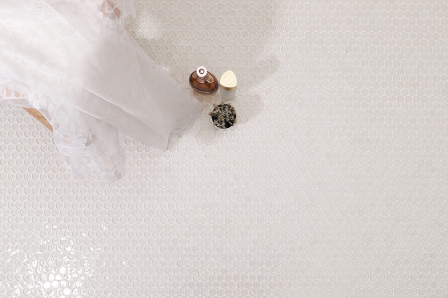 Penny round tiles white glass mosaic floor with bath items and sheer fabric