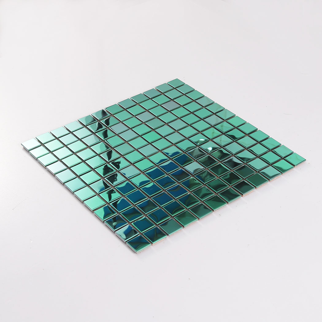 Perspective view of a green metal mosaic tile sheet lying flat on a white background