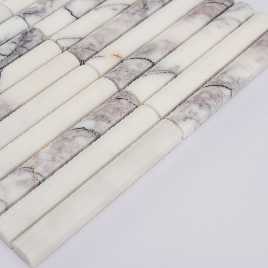Angled shot highlighting the thickness and natural grey veins of white marble pencil strips.