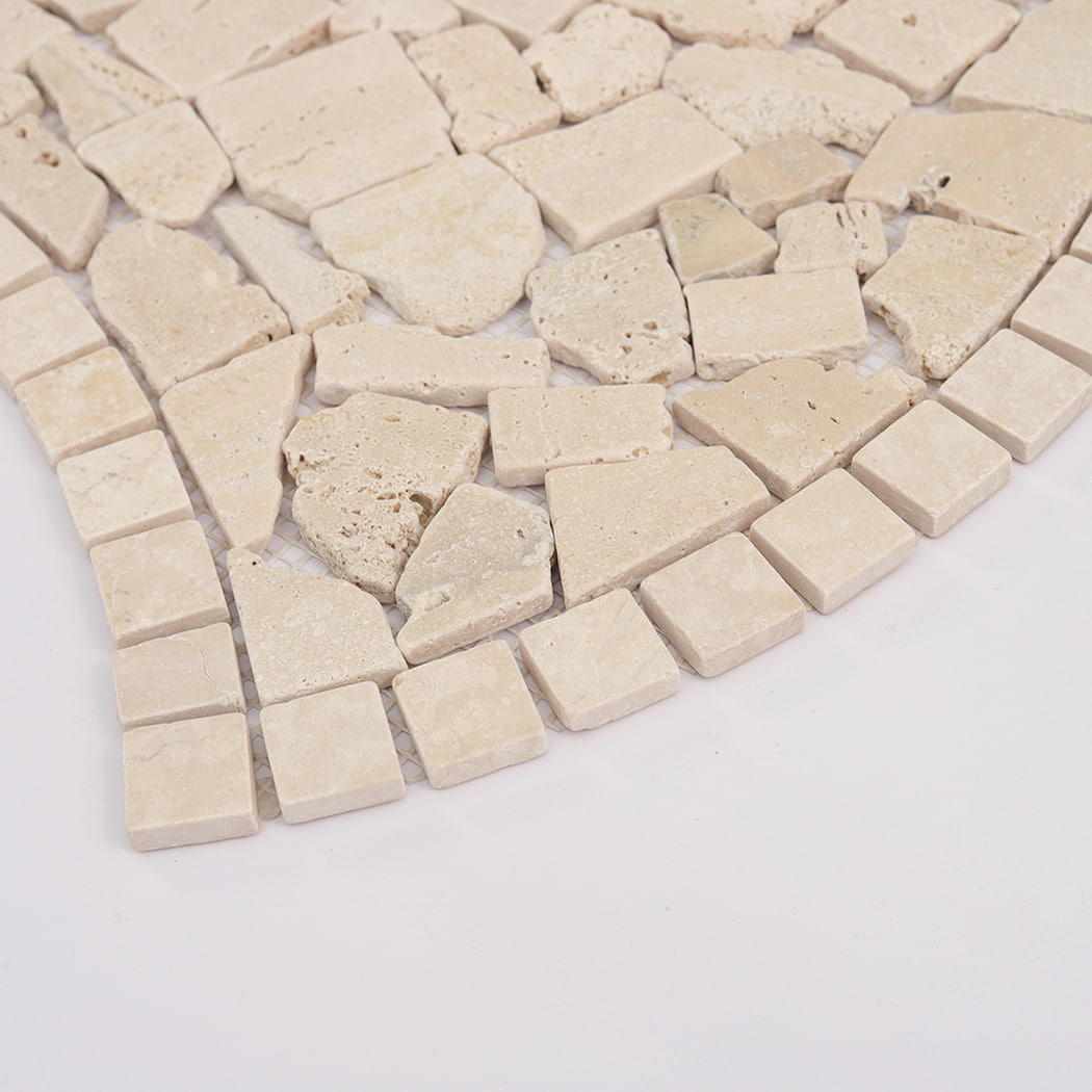 Angled perspective of beige flat travertine pebble mosaic tiles on a mesh backing.