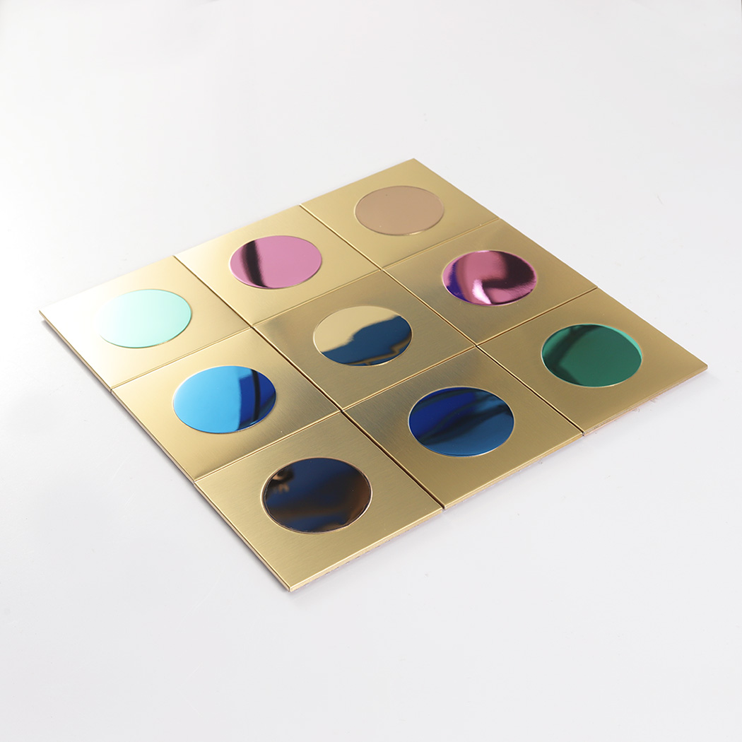 An angled perspective shot of the nine-piece gold and colorful mirror tile set on white.