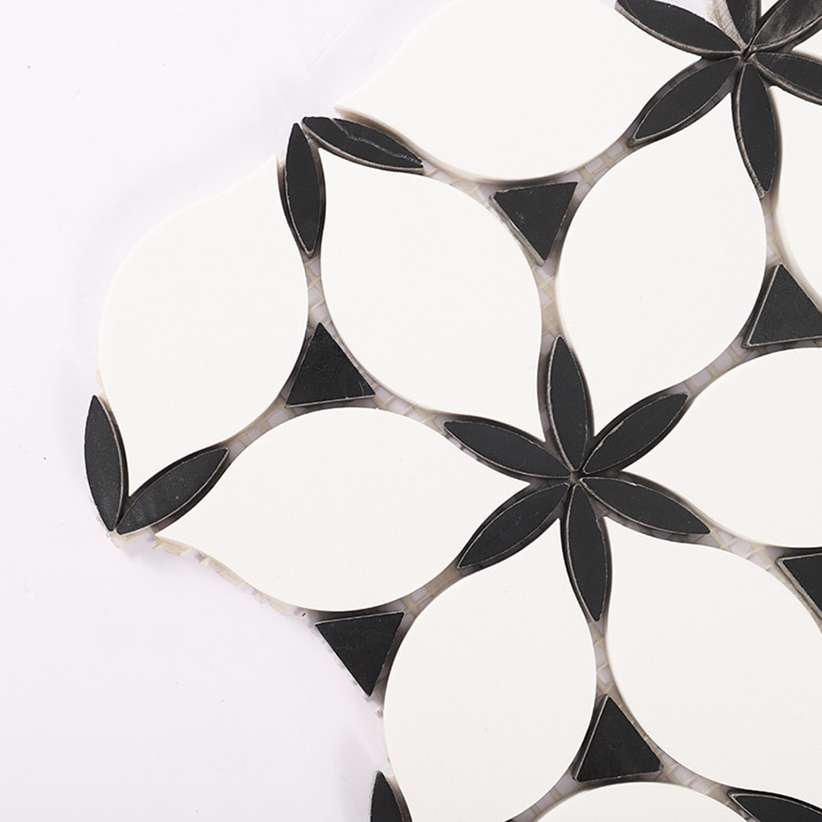Close up of black and white petal marble mosaic tile corner detail.