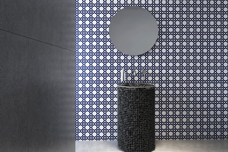 Picket tile bathroom with round mirror and black mosaic pedestal sink