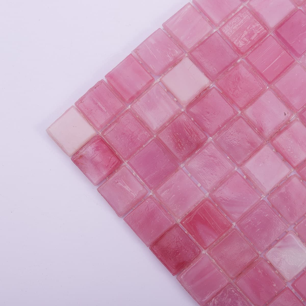 Close-up corner view of pink square glass mosaic tiles with soft texture