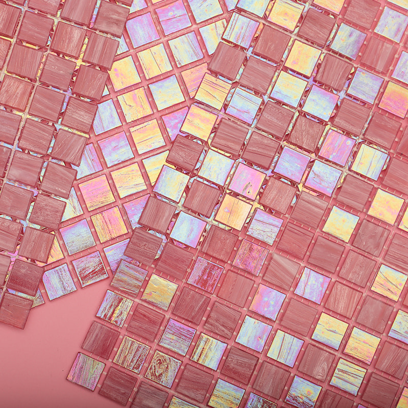 Overlapping iridescent and matte pink glass mosaic tile sheets displayed on a pink background.
