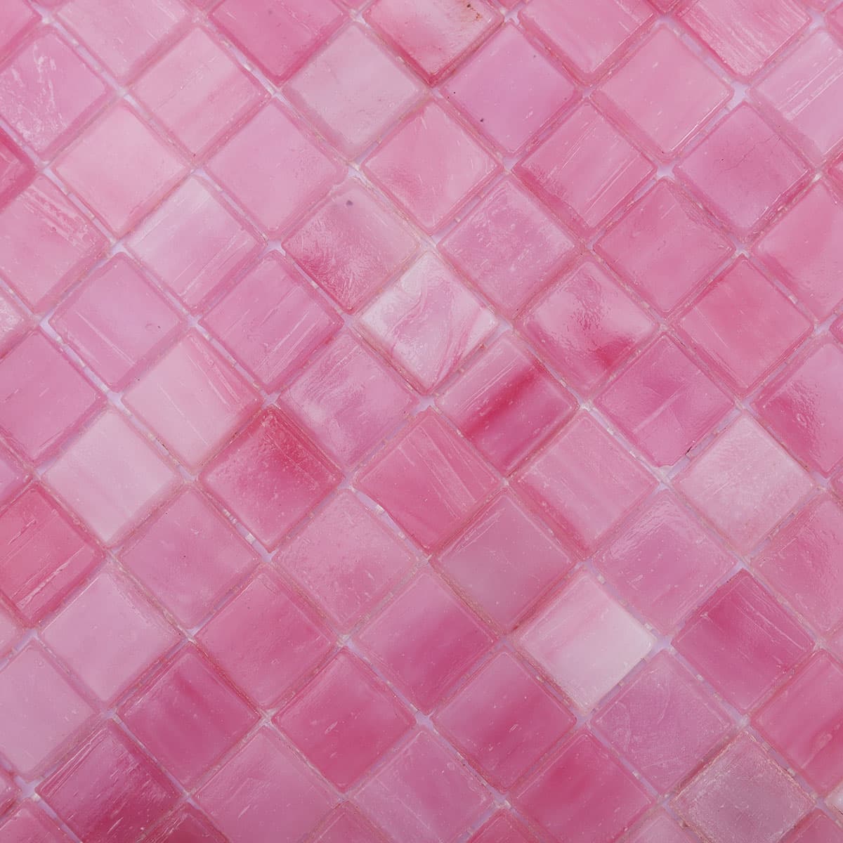  Macro view of pink square glass mosaic tiles showing color variation and glossy surface