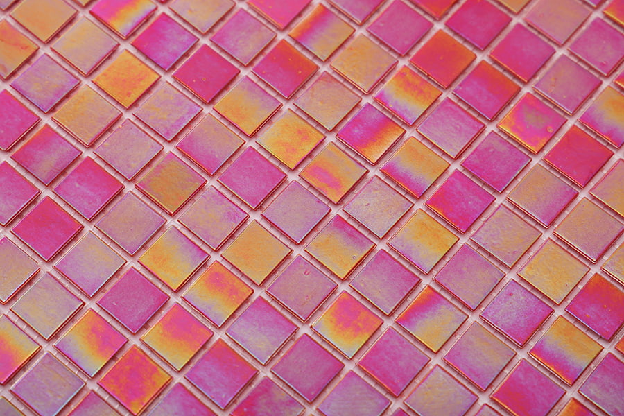 A broader view of pink glass mosaic tiles displaying iridescent orange reflections 