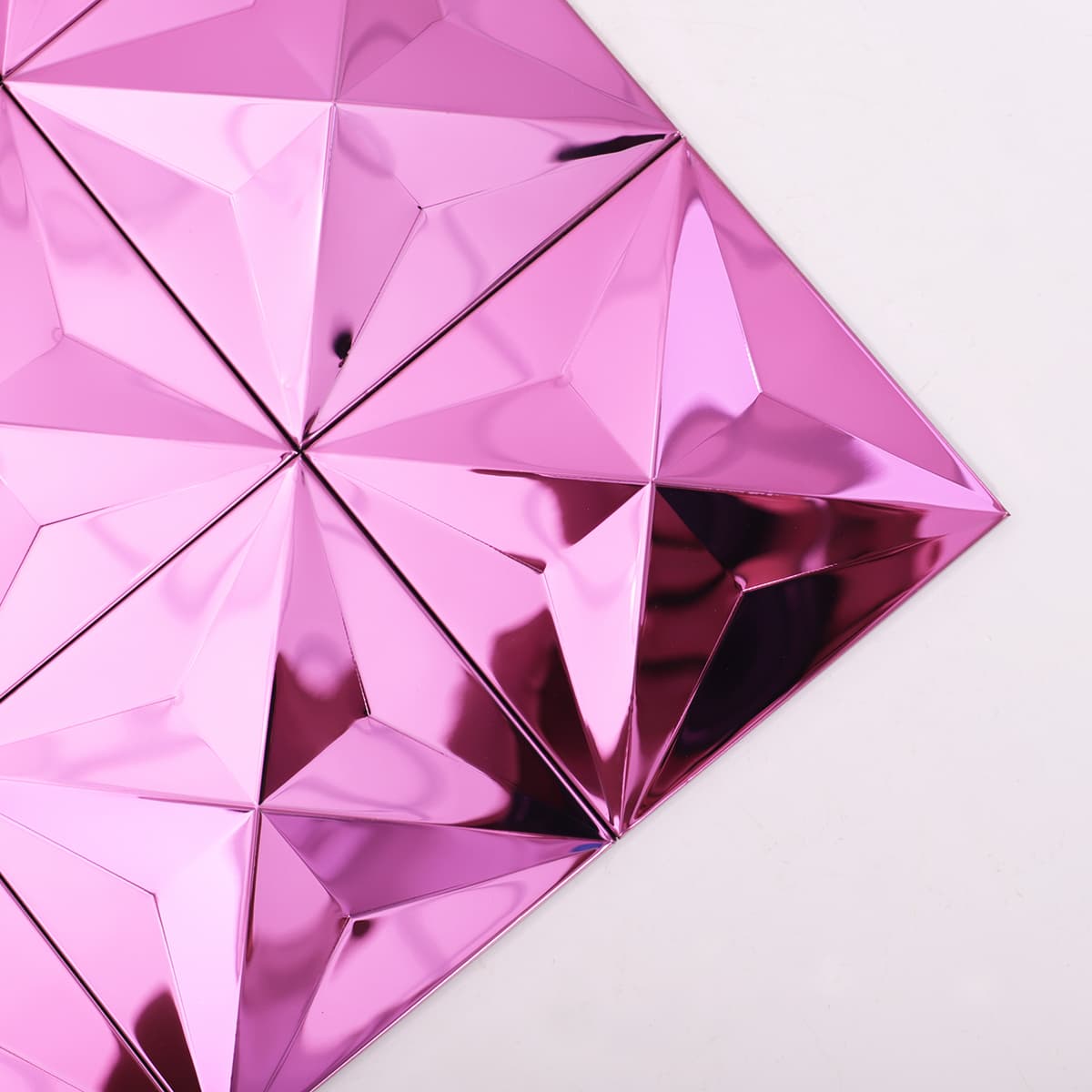 Angled close-up of pink mirror stainless steel mosaic tiles