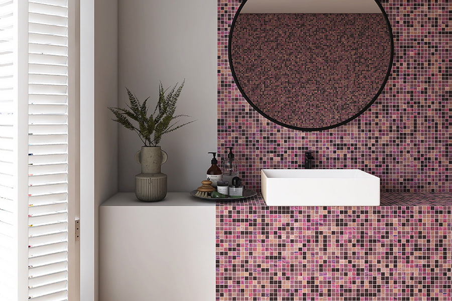 Contemporary bathroom with pink mosaic tiles, white sink, and round mirror.
