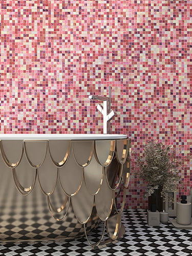 Pink square mosaic tile wall with scalloped gold bathtub edge and bath accessories