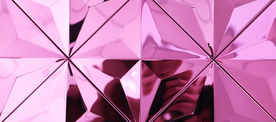 Close-up of pink 3D geometric stainless steel mosaic tile with reflective facets 