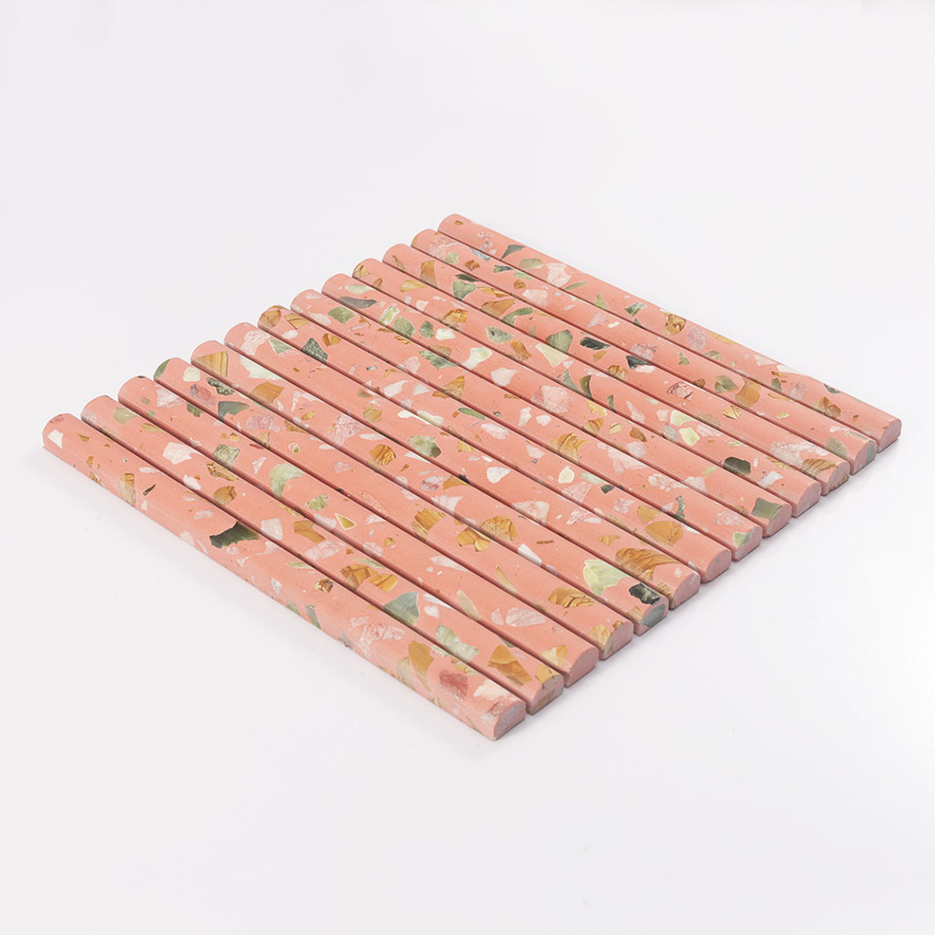 Side view of pink terrazzo rounded fluted mosaic tile on a white background