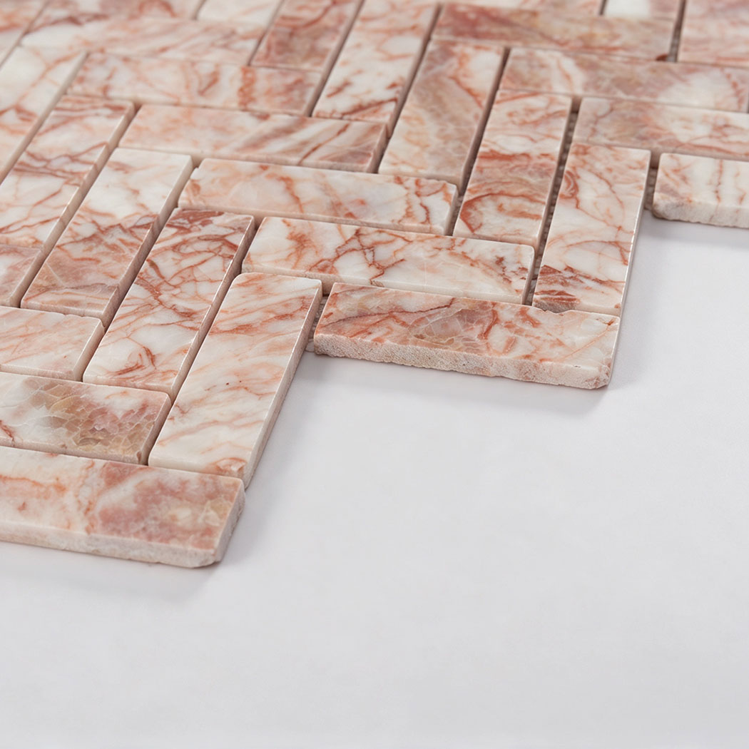Angled view showing the thickness of pink and white herringbone marble mosaic tile