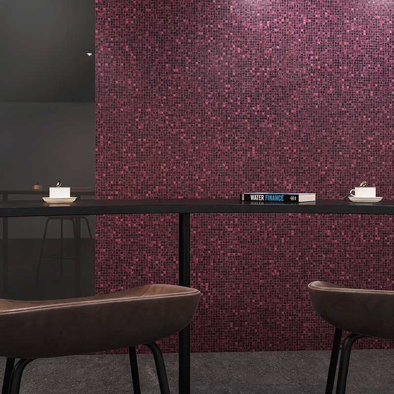 Front view of a bar counter with two leather stools in front of a purple mosaic tile wall 