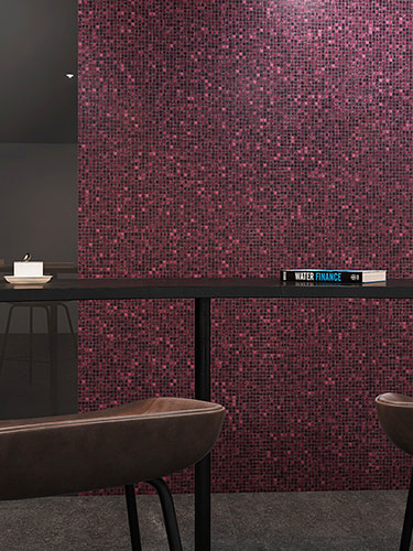 Side angle view of a sleek black countertop and book against a purple mosaic tile wall