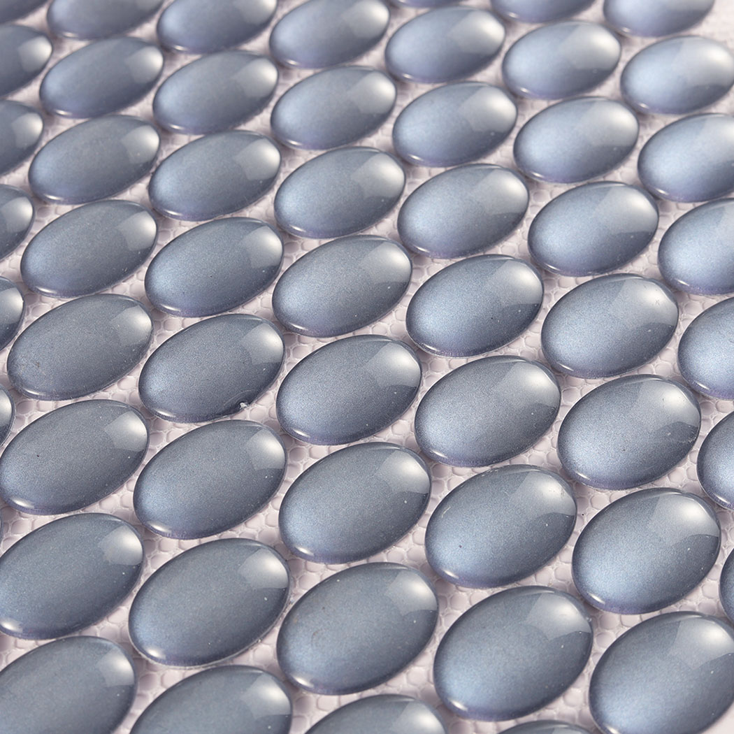 Close pattern of raised blue gray oval glass mosaic chips on mesh backing