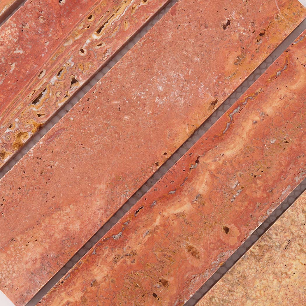 Detailed view of warm red travertine mosaic strips with organic stone markings