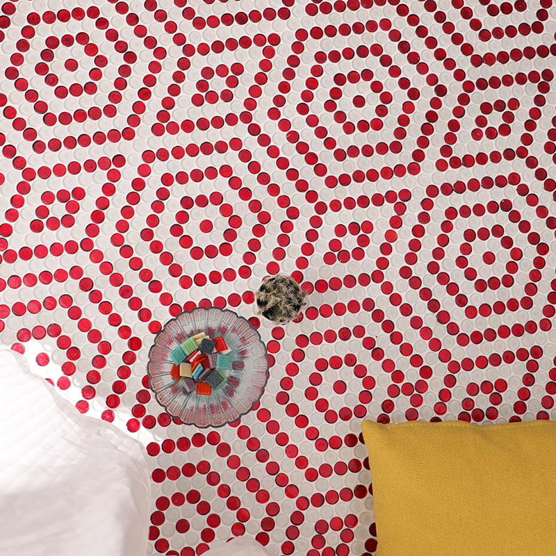 Top-down view of white and red penny round tiles arranged in hexagon shapes with cactus accent
