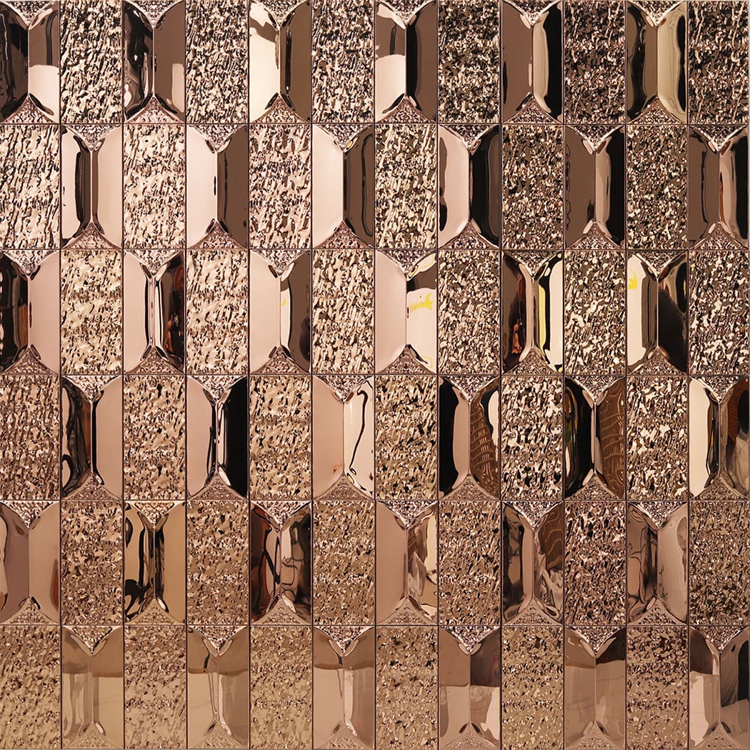 Shiny reflections on a rose gold 3d metallic mosaic tile wall.
