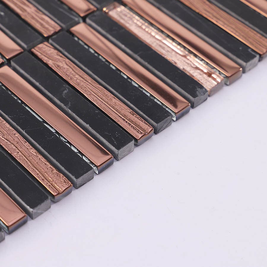 Side angle view of rose gold glass and black marble mosaic linear tile