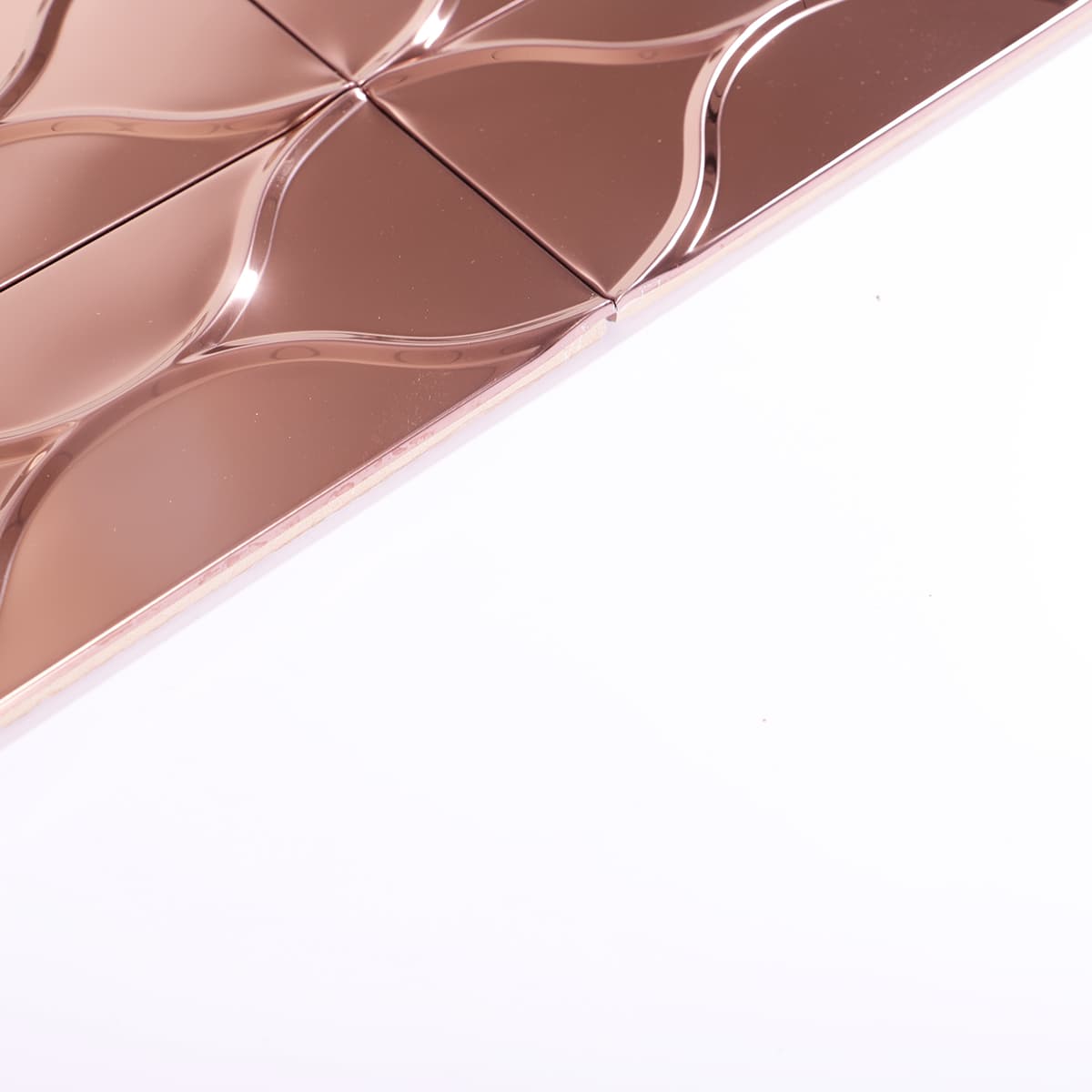 Close-up showing edge thickness and gloss of rose gold mirror tile