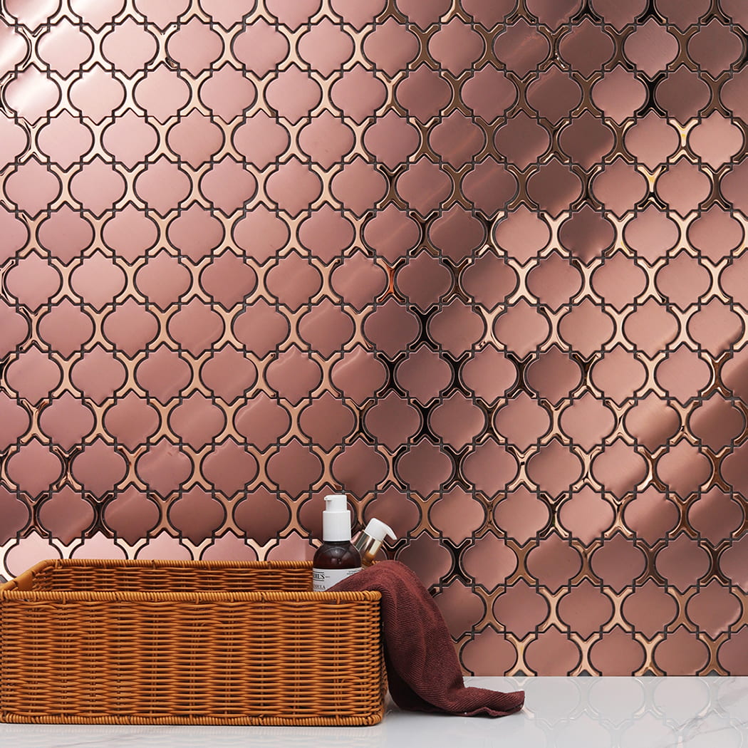 Shiny reflections on rose gold metal tiles arranged in an arabesque pattern.