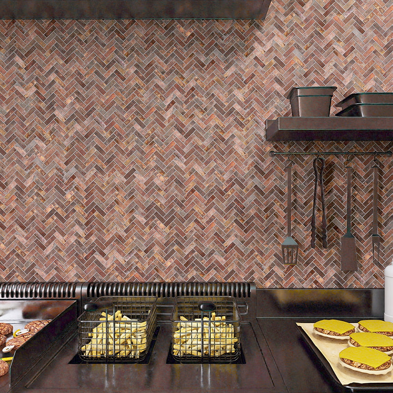 Kitchen stove and utensils against rust-brown herringbone tile backsplash
