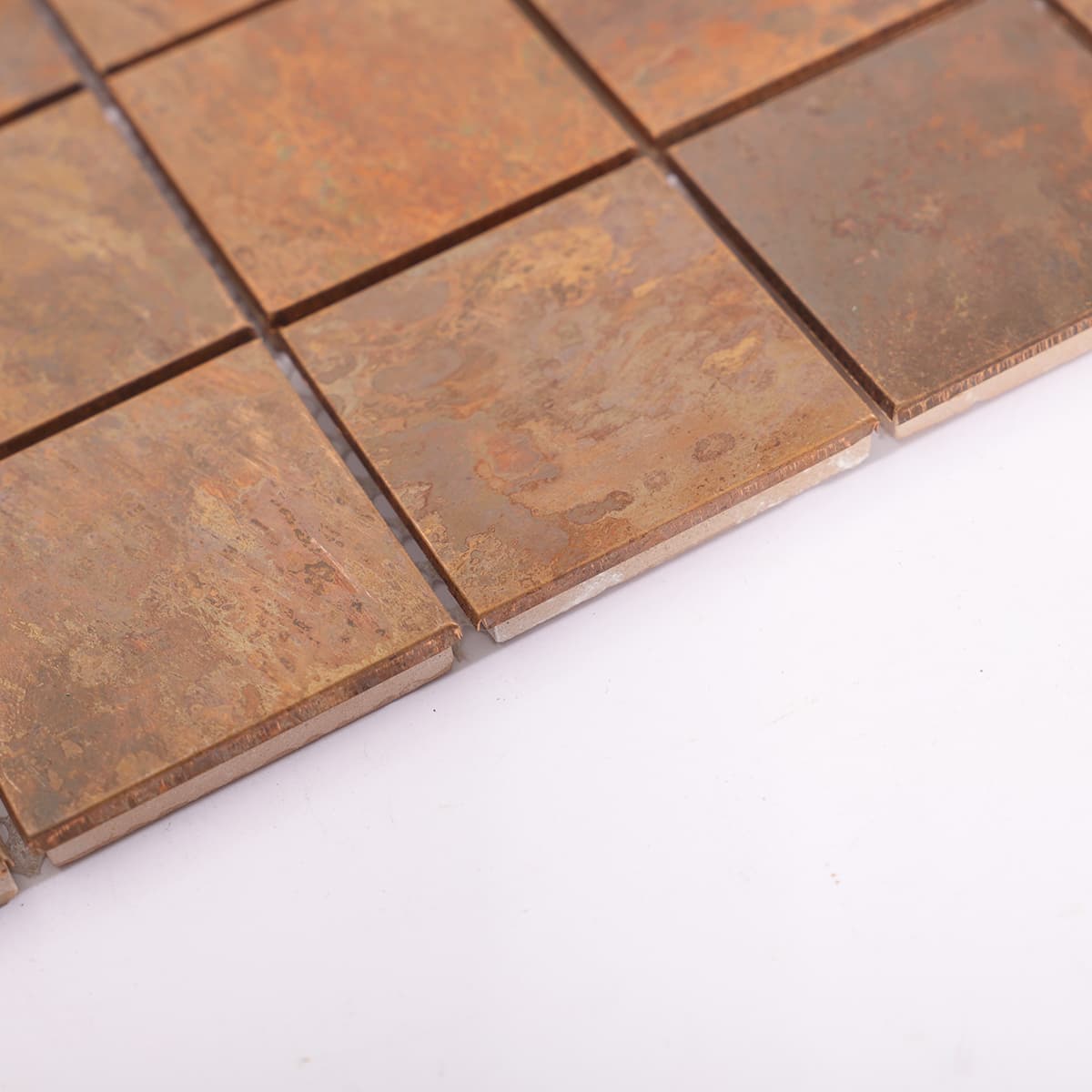 Edge view of copper mosaic tile with rustic finish