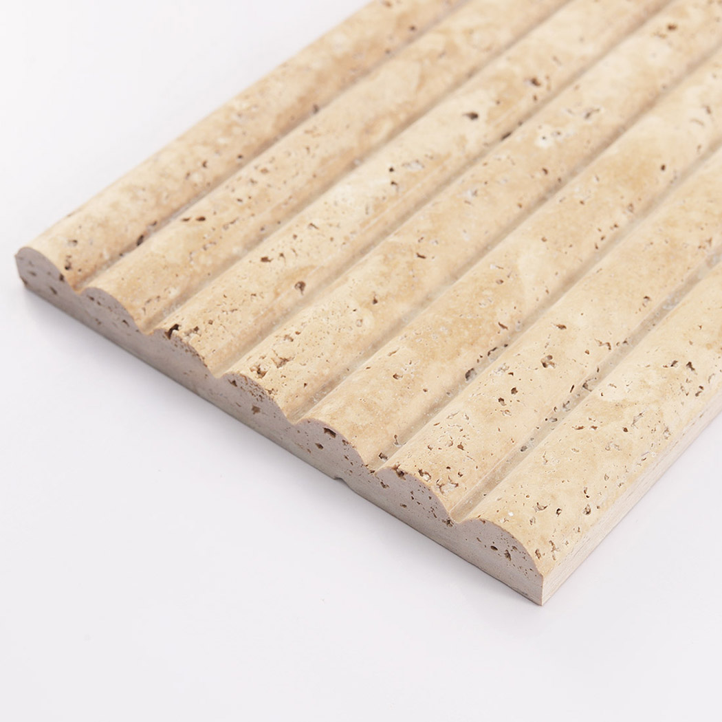 Close up of the wavy fluted edge and porous texture of a beige travertine stone tile.